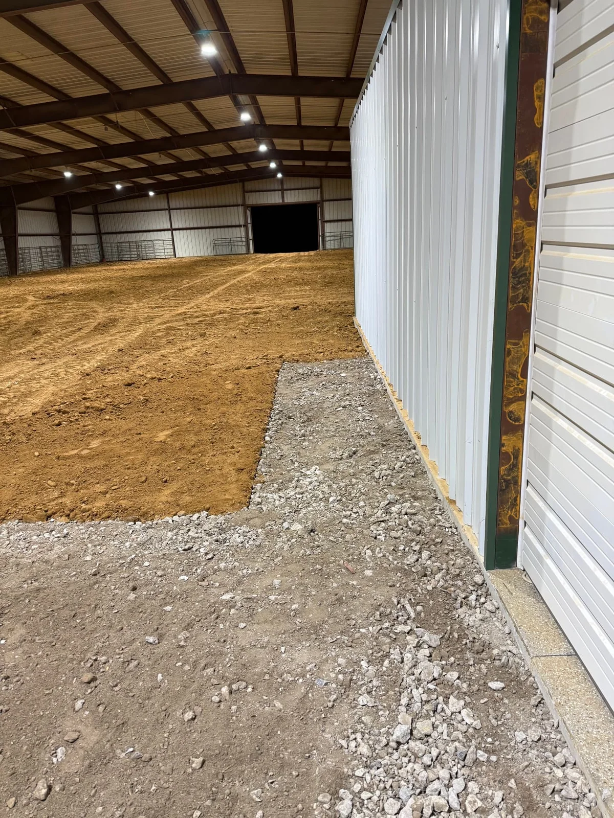 Graded and compacted rock surface transitioning into an arena access area
