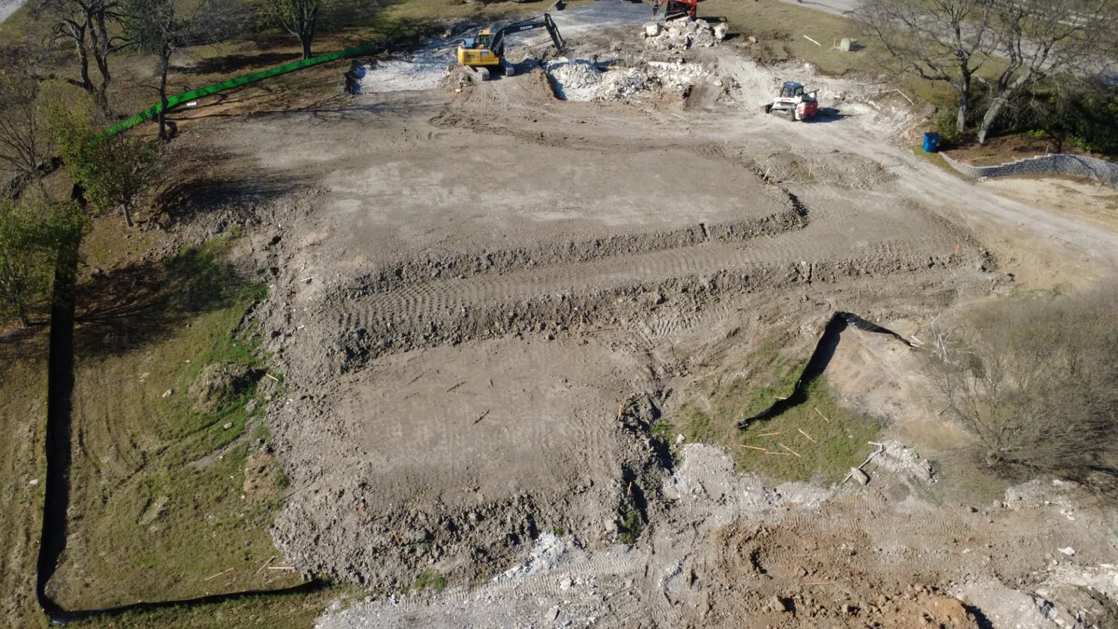 Aerial view of a tiered house pad under construction on a hillside lot in Fairview, Texas