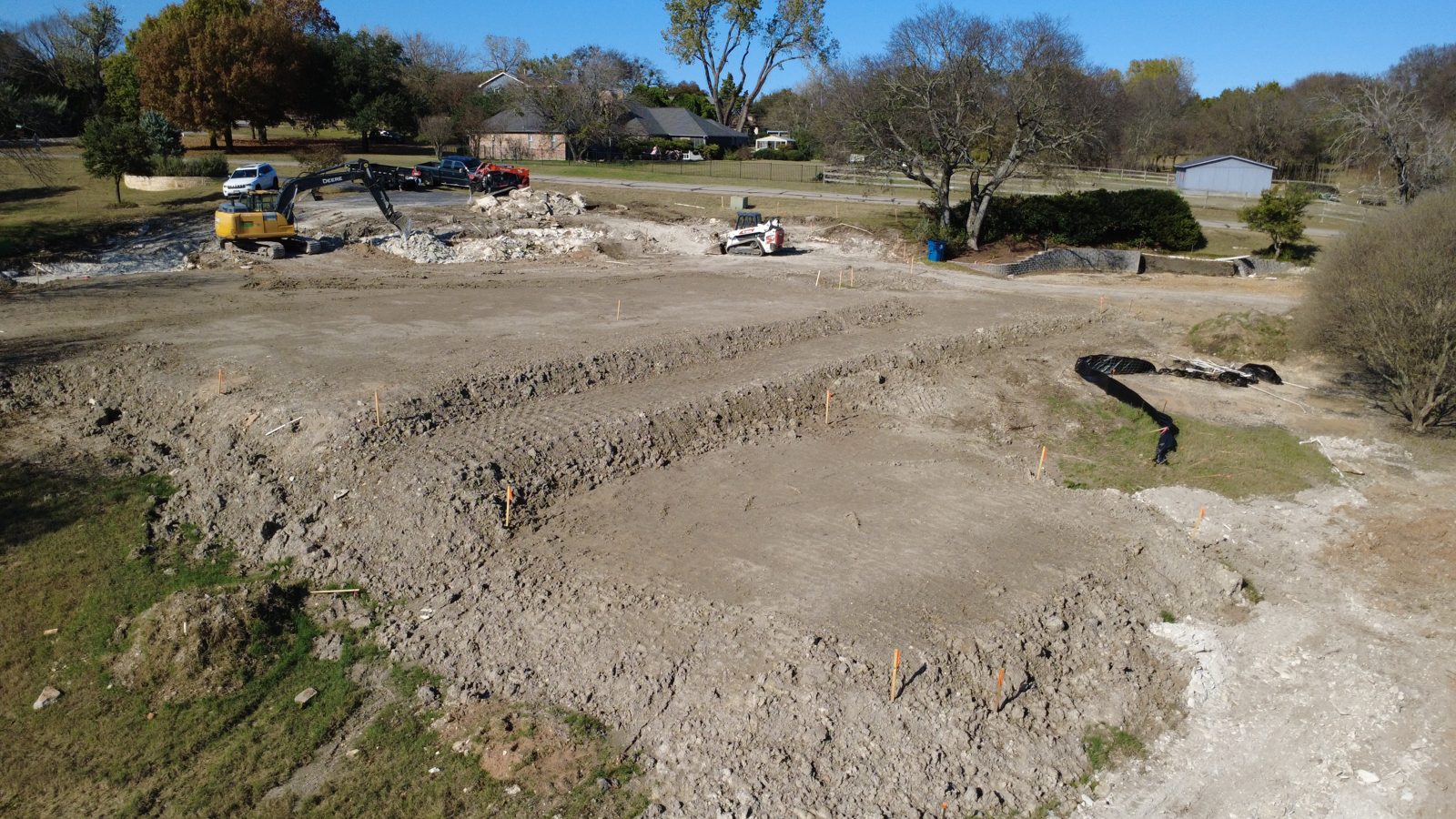 Excavation services across open acreage with equipment working a large cut